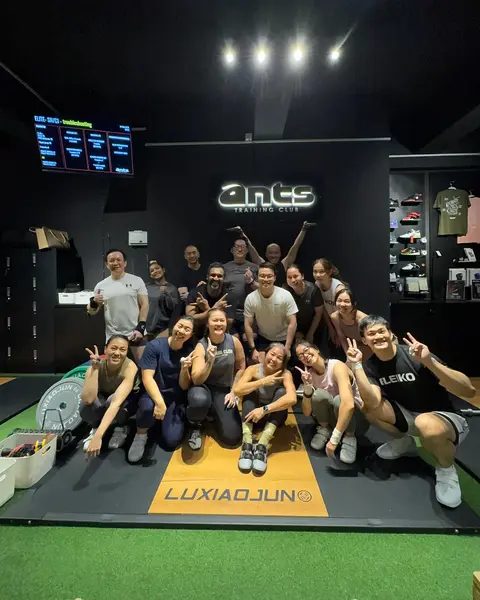 Members of the Olympic lifting class gathered under the ANTS Training Club sign.