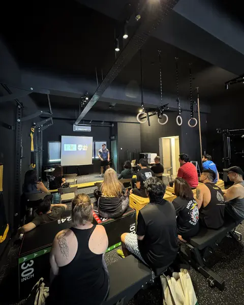 Attendees seated facing a projector screen during a seminar held on the training floor.