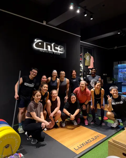 A full strength and conditioning class gathered under the ANTS Training Club sign.